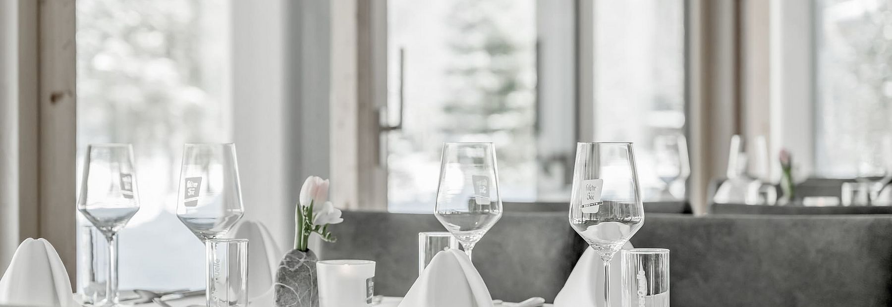 Gedeckter Tisch mit Weingläsern im Restaurant des Hotel Fischer am See im Winter