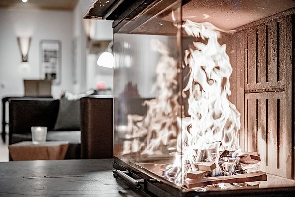 Nahaufnahme eines flackernden Kaminfeuers in gemütlicher Hotel-Lounge