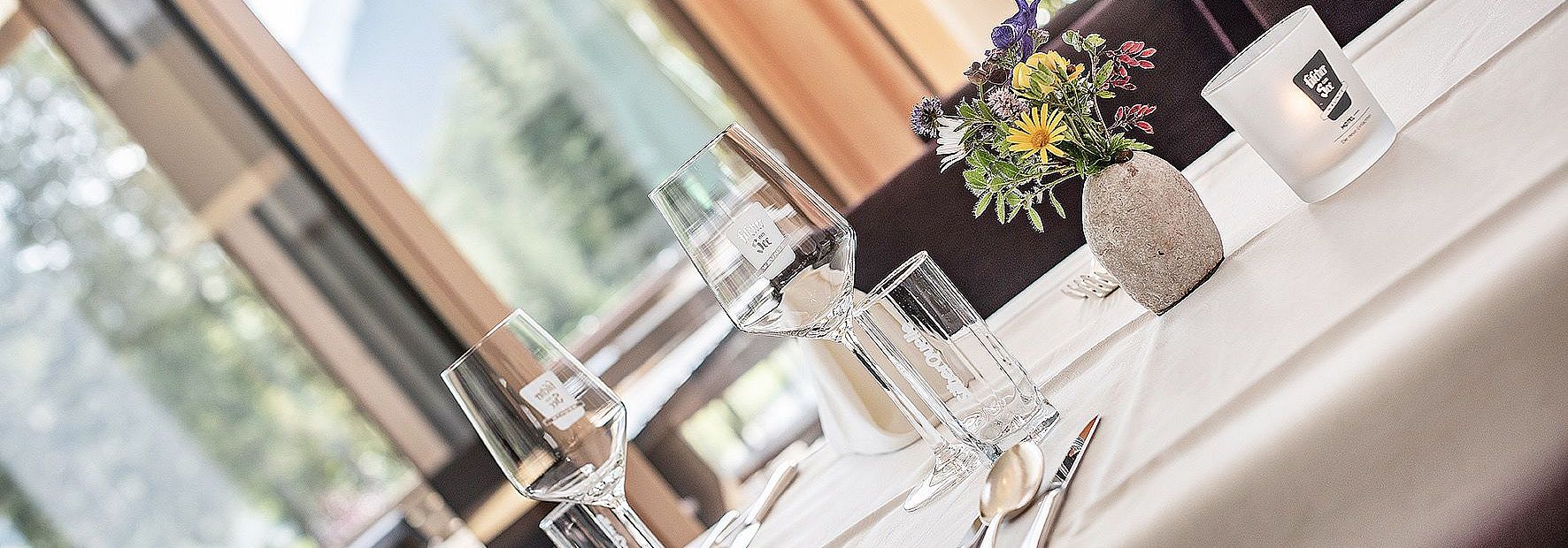 Gedeckter Tisch mit Weingläsern im Restaurant des Hotel Fischer am See im Sommer