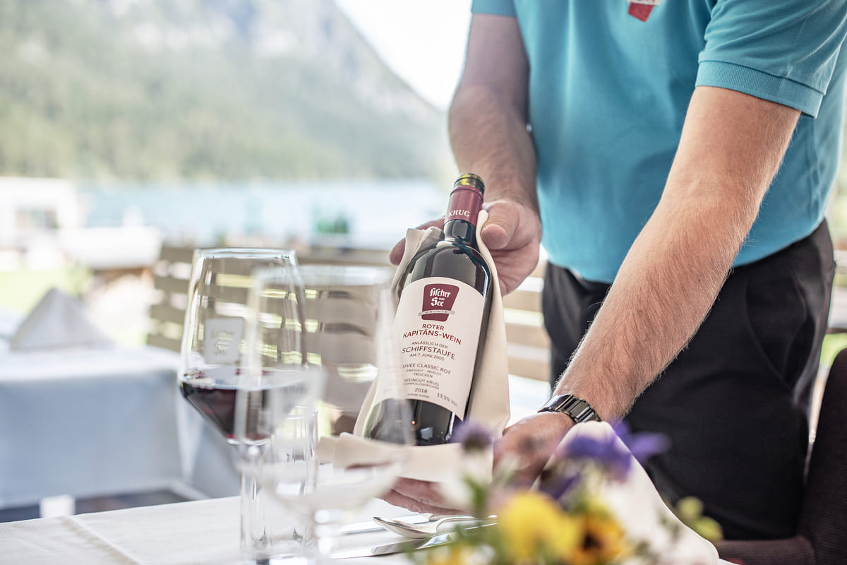 Kellner serviert Rotwein im Hotel Fischer am See im Sommer auf der Terrasse
